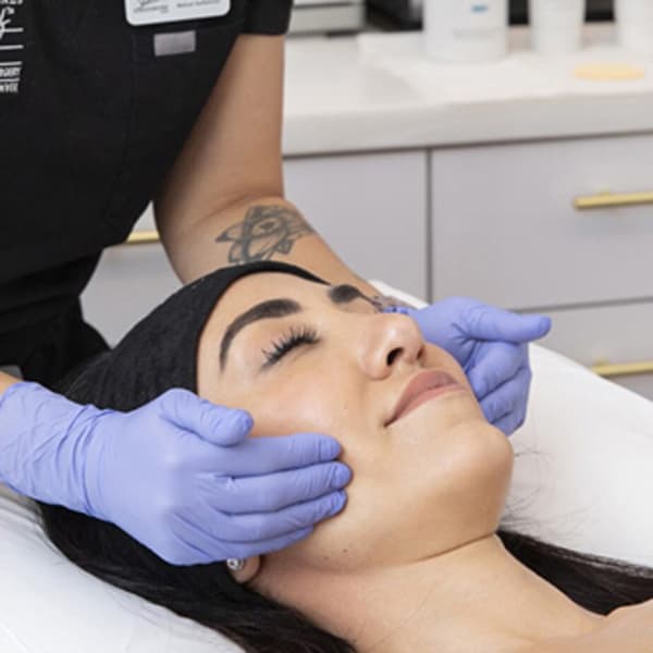 Licensed aesthetician performing a professional facial treatment