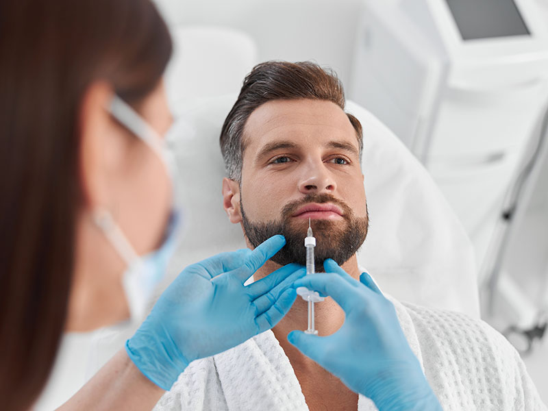 Medical provider administering a cosmetic injectable treatment to a male patient.