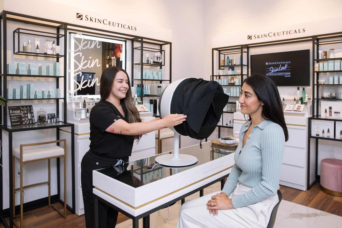 Skincare professional using a facial analysis device during an in-office skin consultation.