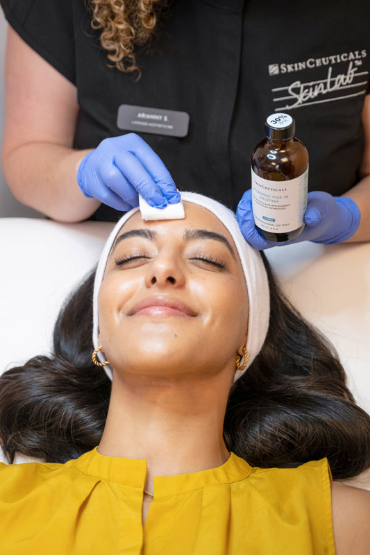 Aesthetic provider applying a professional skincare treatment to a patient’s face.