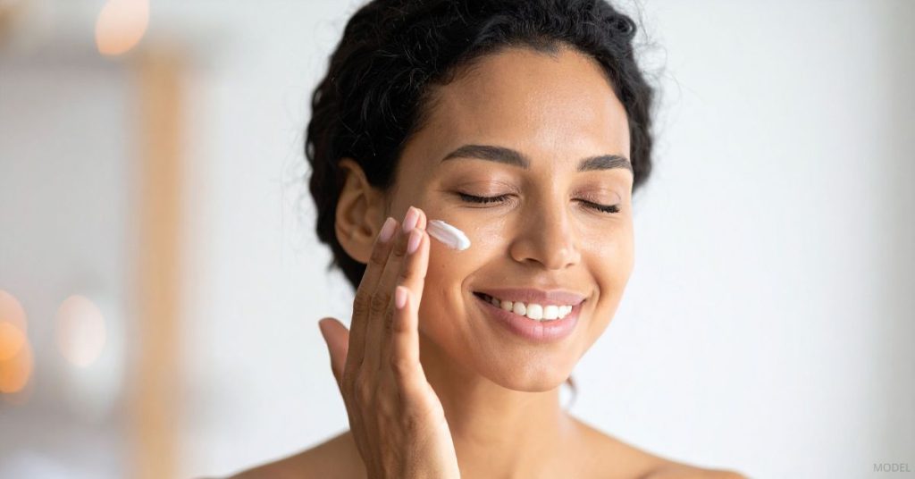 Woman applying skincare after laser treatment. (Model)